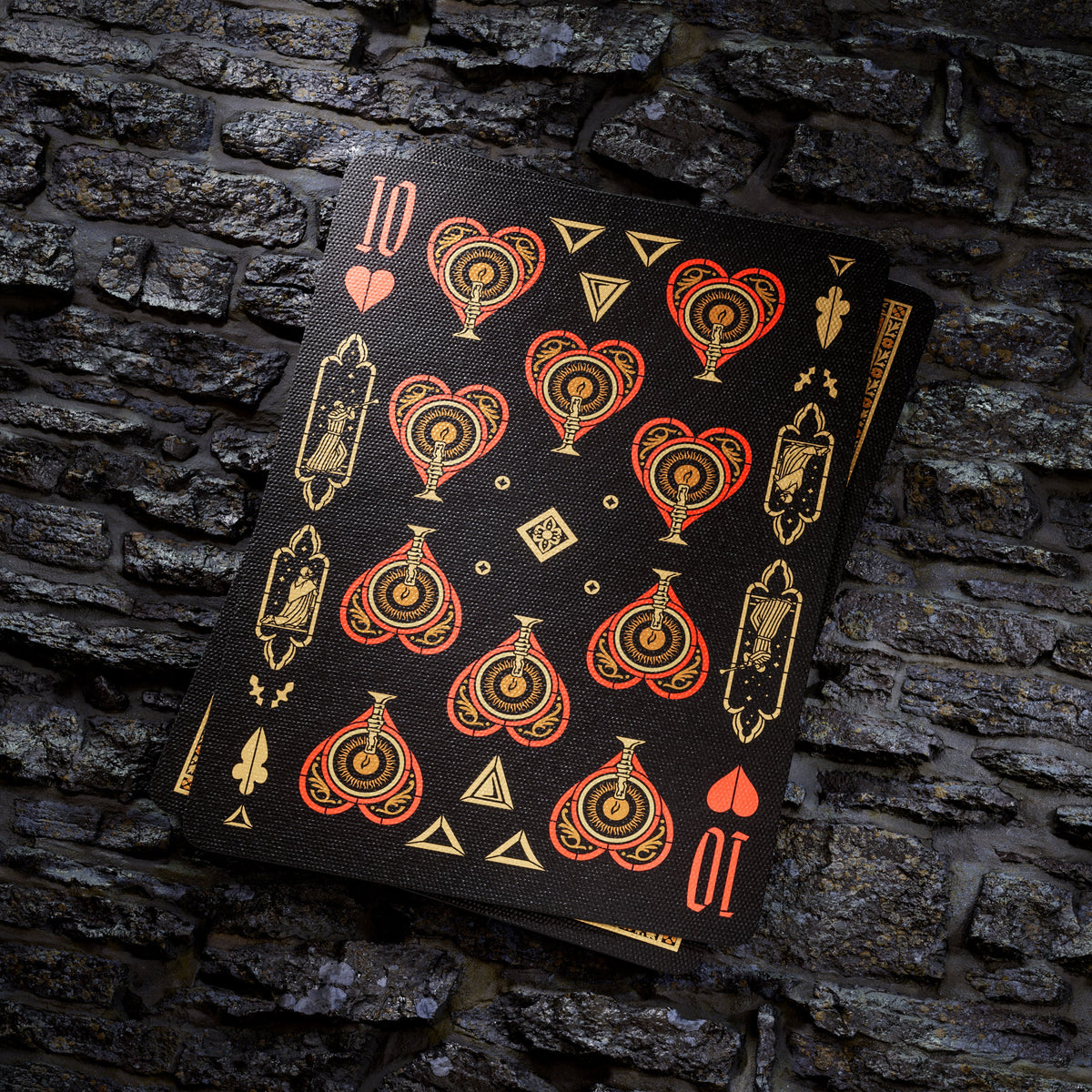 Theory11 Kovadrin Ten of Hearts showing red-and-gold ornamental heart pips and small illustrated details on black.