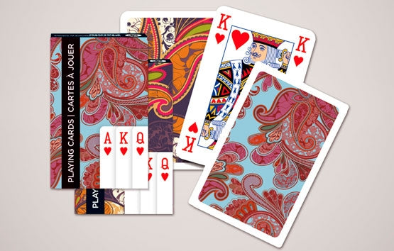 Playing cards with colorful paisley design on a beige background