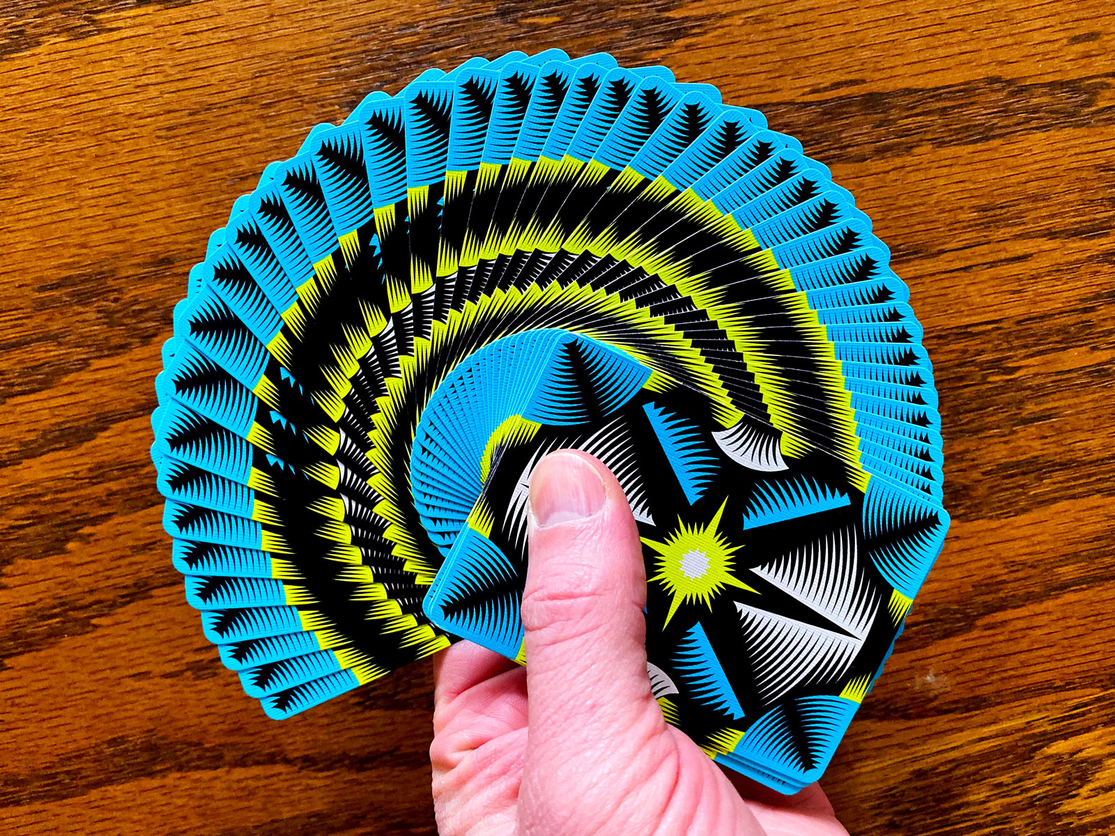 Polaris Winter Solstice Playing Cards fanned to show the vivid borderless cyan, yellow, white and black card backs