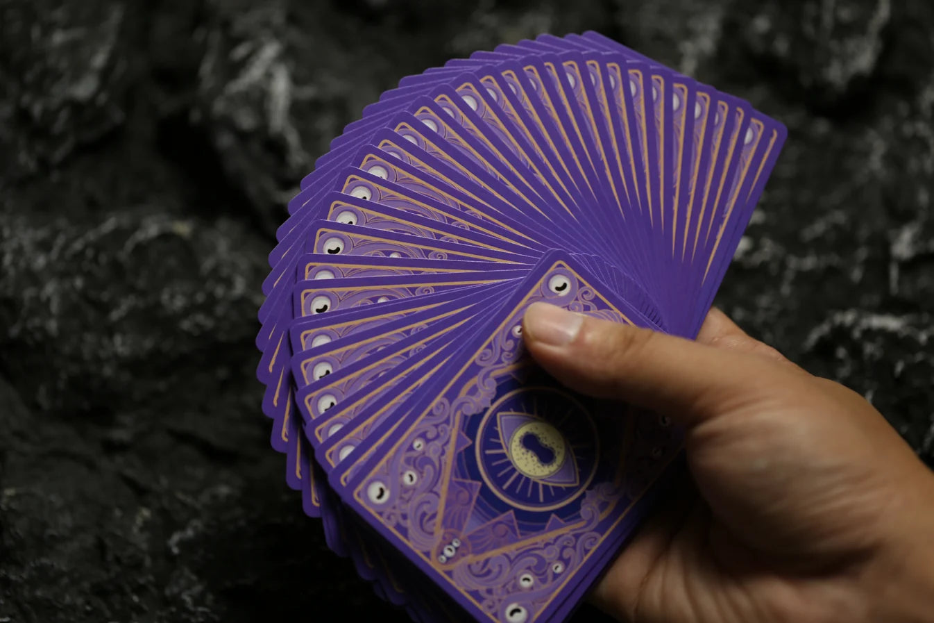 Purple Arkham Archives playing cards fanned to show the custom eye and Keyhole back design