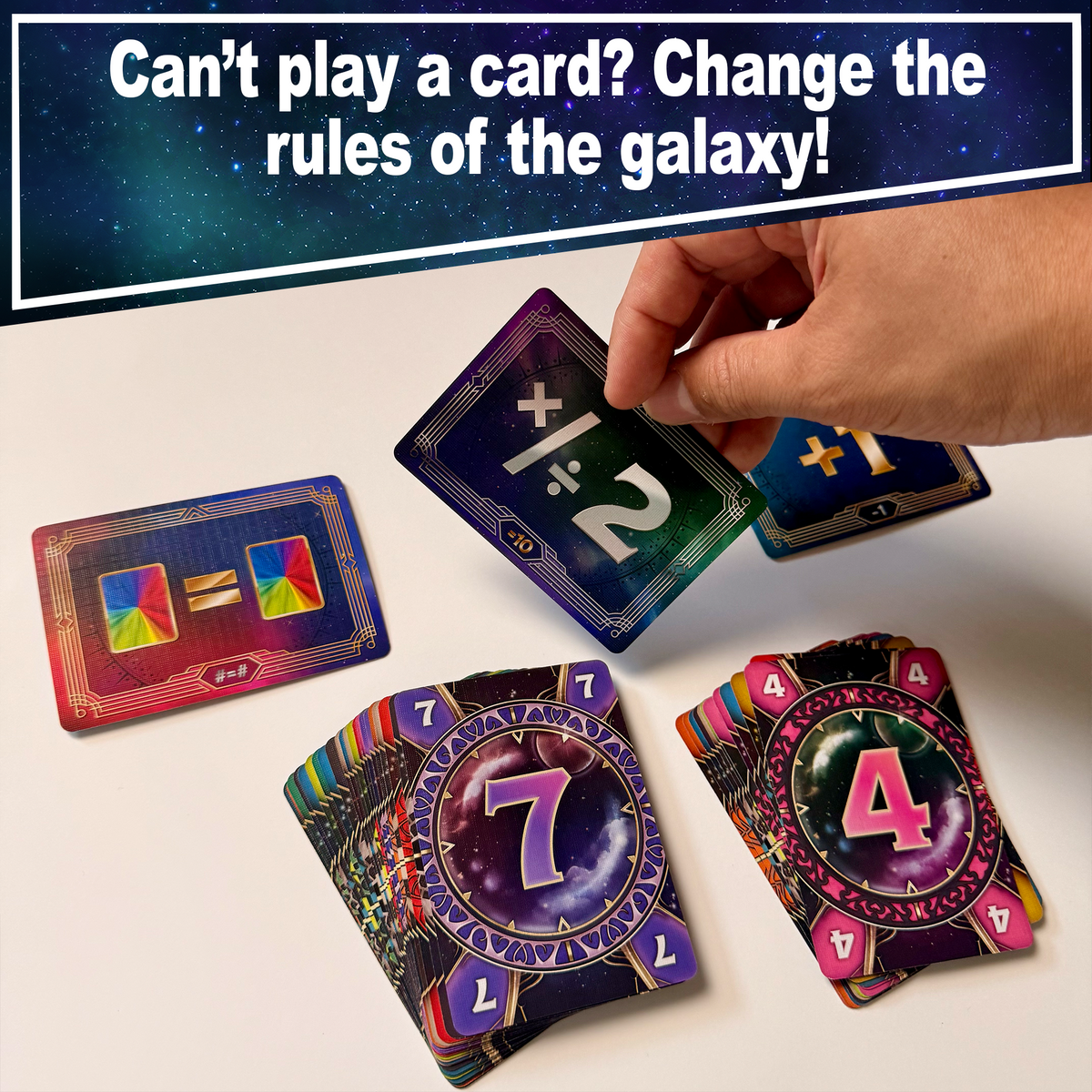 A hand changes a Warp 99 galaxy rule beside numbered playing cards.
